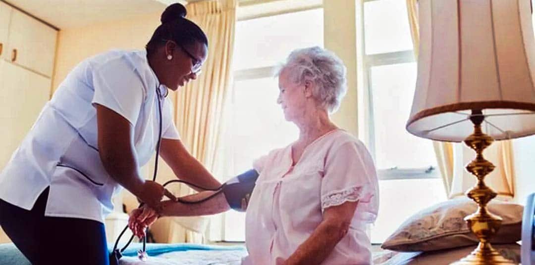 Nurse checks blood pressure of a retired senior health care patient in Alachua County FL